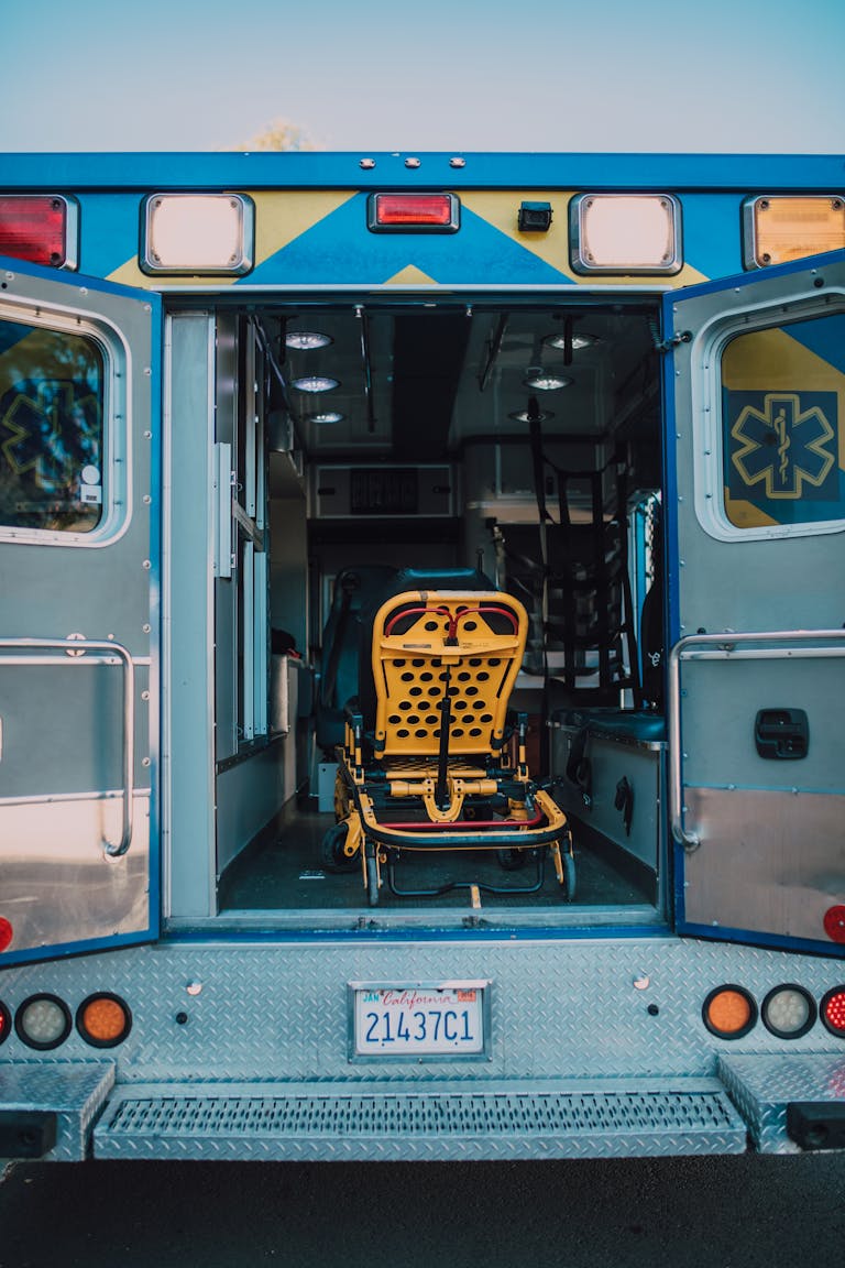 Rear view of an open ambulance with an empty stretcher on a sunny day.